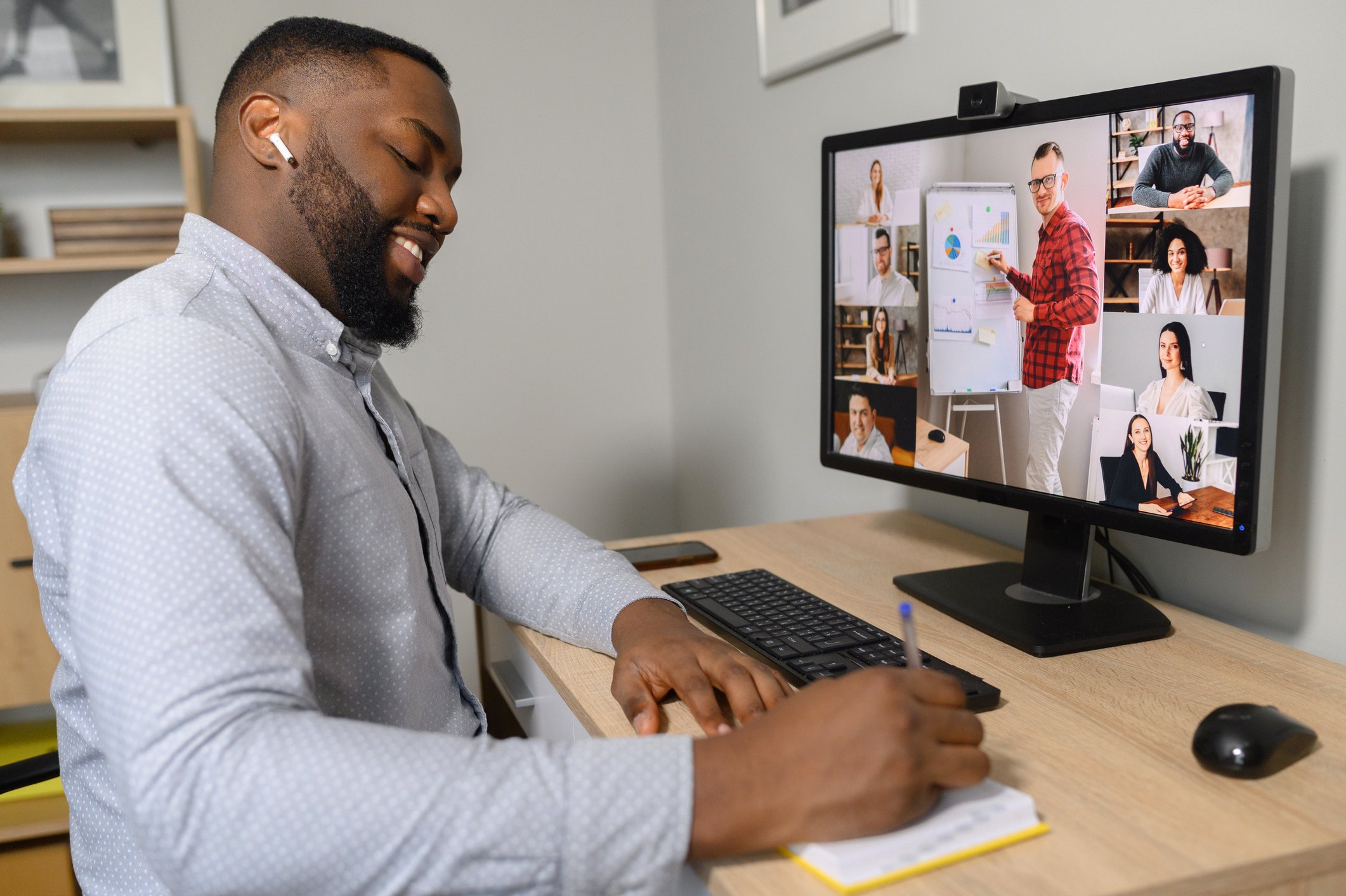 Man participating in a team meeting from home office Man participating in a team meeting from home office